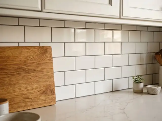 New white subway tile backsplash above a light countertop and white cabinets